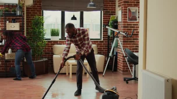 Unge Livsledsagere Gør Husholdningsarbejde Rengøring Lejlighed Med Støvsuger Afrikansk Amerikansk – Stock-video
