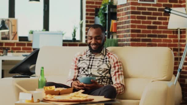 African American Person Opening Television Find Movie Eating Chips Bowl — Videoclip de stoc