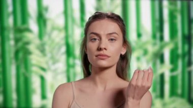 Luminous radiant woman posing with confidence, creating self love skincare ad campaign in studio. Beautiful smiling girl feeling happy over bamboo trees background, self acceptance.