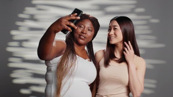 Two Skincare Models Taking Photos Smartphone Diverse Young Women Advertising — 图库视频影像