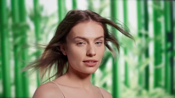 竹の背景に不完全さを受け入れる白人女性 カメラでシャンプーとコンディショナーを促進 若い完璧なモデル広告ヘアケアと美容ルーチンでスタジオ — ストック動画