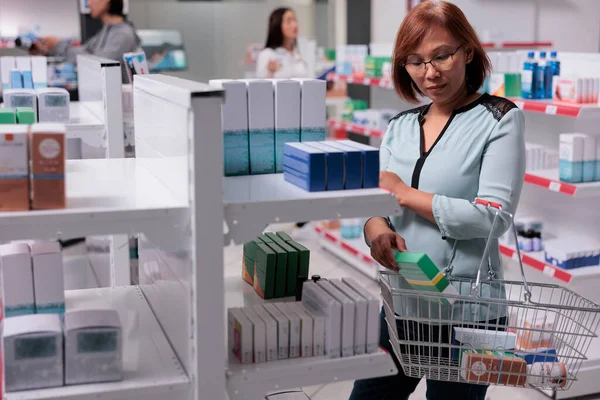 Asian Woman Examining Vitamins Box Shelves Looking Buy Medical Supplements — Stock Photo, Image