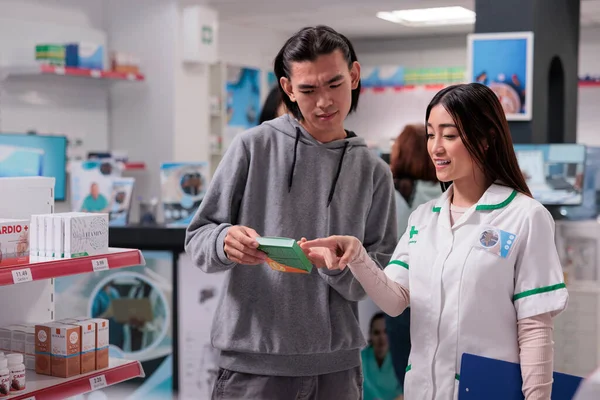 Asian Person Consultant Talking Vitamins Box Explaining Supplements Leaflet Pharmacy —  Fotos de Stock