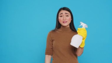 Professional maid pointing and showing cleaning product or isolated text, using chemical spray bottle filled to disinfect surfaces and prevent the spread of germs. Housecleaning concept