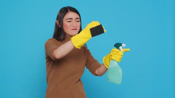 Overwhelmed Maid Standing Studio Blue Background Doing Intensive Cleaning Using — Stockvideo