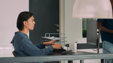 Uçbirim penceresindeki Asyalı web geliştirici güvenlik duvarı sunucusunu programlayarak, bilgisayarda yeni bir kullanıcı arayüzü yaratıyor. Ajans ofisinde kodlama dili ve bulut bilgisayarı üzerinde çalışan bilişim mühendisi..