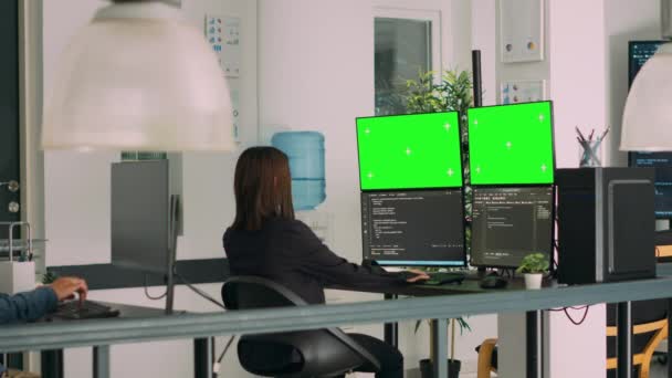 アジアのシステムエンジニアは ソフトウェアイノベーションオフィスの複数のモニターでHtmlスクリプトコードとグリーンスクリーンを使用しています ターミナルウィンドウと隔離されたクロマキーディスプレイで作業しているプログラマー 三脚ショット — ストック動画