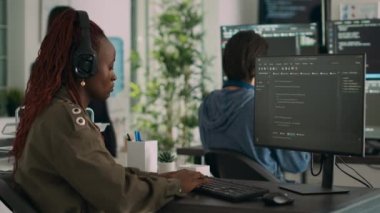 African american software engineer working focused on programming it language at computer, typing html script. Database programer writing code with algorithms on terminal window.