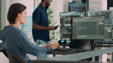 Yazılım geliştiricisi bilgisayarda öğrenme uygulaması kodları yazıyor, büyük veri ofisindeki masada oturuyor. Bulut programcısı siber güvenlik ajansında Html veritabanı senaryosu üzerinde çalışıyor. El kamerasıyla..
