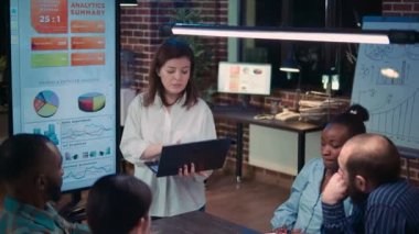 Employee speaking in business meeting presentation, holding laptop, financial analytics report. Team working on company research statistics, planning marketing strategy, discussing charts