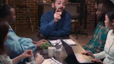 Şirket ekibi iş toplantısında beyin fırtınası yapıyor, sunumu tartışıyor, çeşitli iş arkadaşlarıyla iletişim kuruyor. Çalışanlar birlikte çalışma alanında gece vakti satış stratejisi planlıyorlar