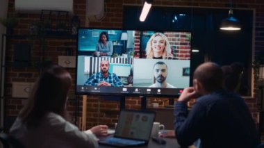 Telekonferans uygulamasında uzaktan kumanda ekibiyle strateji planlayan çalışanlar, video konferansında beyin fırtınası yapan iş arkadaşları. Çeşitli ofis çalışanları online iş toplantılarında sunum dinliyorlar. El kamerasıyla..