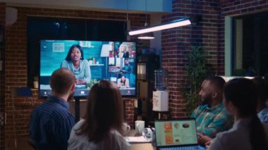 Business analytics discussion with remote team in videconference application, employees talking in videocall at night time. Office workers chatting in teleconference in boardroom