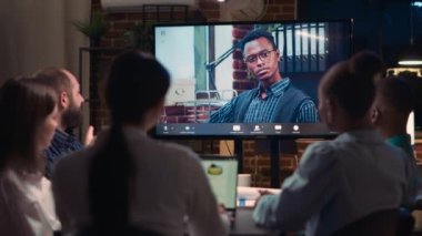 Uzaktan kumandalı ekip lideri video konferansında çalışanları dinliyor, çeşitli insanlar gece video konferansında konuşuyor. Ofis çalışanları telekonferansta sohbet ediyor, yöneticiler konuşuyor. Üçayak atışı.