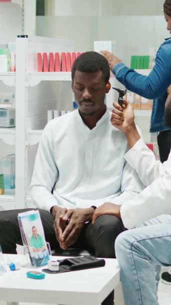Vertical Video Male Doctor Consulting Customer Otoscope Clinic Sitting Drugstore — Vídeo de Stock