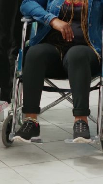 Vertical video: Pharmacy consultant helping client with disability, talking to woman and social worker in pharmaceutical store. Health specialist giving medicine and vitamins to customers, medical