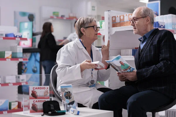 Empleado Farmacia Explicando Instrucciones Dosificación Suplementos Cardíacos Paciente Anciano Escuchando — Foto de Stock