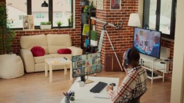 Evdeki çevrimiçi video görüşmesine katılan şirket çalışanı telekonferans görüşmesinde iş arkadaşlarıyla konuşuyor. Video konferansta web kamerasını kullanarak sohbet etmek, evden masa başında çalışmak..