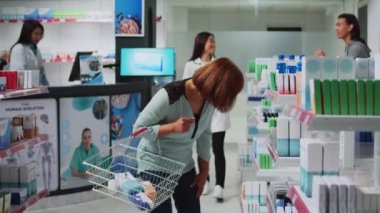 Eczacı, eczanedeki ilaç ve ilaçlarla müşteriye yardım ediyor. Reçeteli ilaç ve vitaminleri açıklayan tıbbi danışman. Müşteri ve uzman ilaç kutusuna bakıyor..
