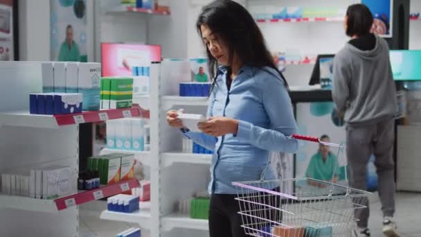 Asian Woman Examining Boxes Medicine Pharmacy Shelves Looking Buy Prescription — Video