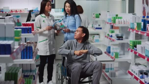 Άνδρας Πελάτης Αναπηρική Καρέκλα Και Επιστάτης Μιλάει Φαρμακοποιό Ψάχνει Αγοράσει — Αρχείο Βίντεο