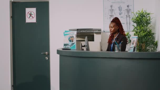 African American Receptionist Giving Assistance Mother Kid Talking Doctor Appointment — Stock Video