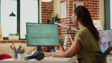 Veri diyagramlarındaki mali raporları analiz eden kadın çalışan, satış bilgilerini bulmak için internet istatistiklerini kullanıyor. Mali pazarlama sonucu için evden çalışan bir kadın. El kamerasıyla..