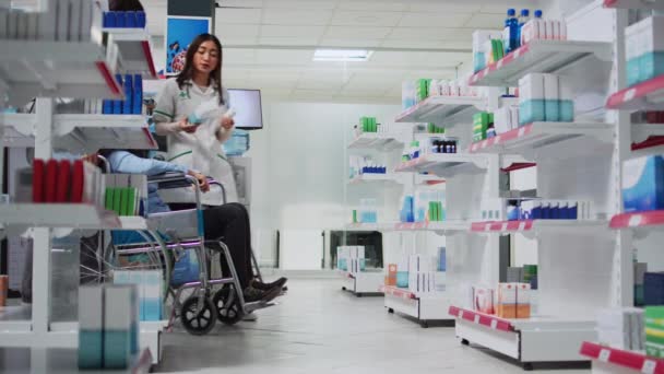 Trabalhador Farmacêutico Dando Pílulas Caixa Para Cliente Cadeira Rodas Zelador — Vídeo de Stock