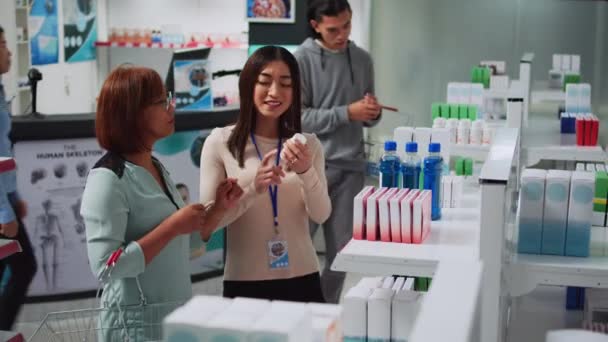 Consultor Farmácia Explicando Vitaminas Para Cliente Feminino Falando Loja Varejo — Vídeo de Stock