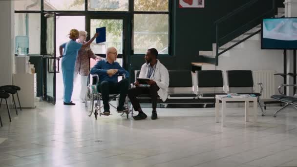 General Practitioner Talking Senior Man Facility Lobby Doing Medical Consultation — Stock video