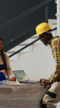 Dikey video: Yönetici, çalışanları depoda boşa zaman harcarken yakalıyor, dağıtım için kutularda ürün paketlemek yerine konuşan ve gülen insanlardan oluşan bir ekip. Denetmen, işçilere iş veriyor..