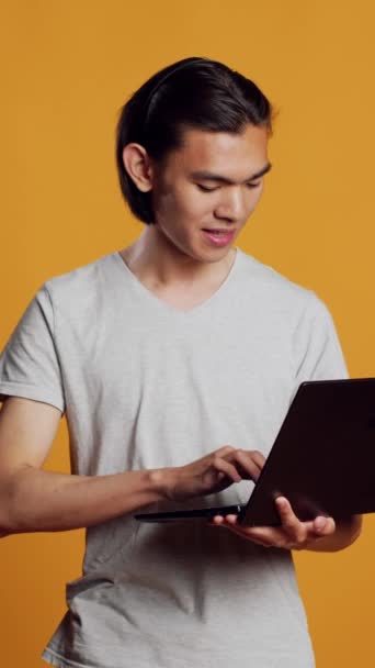Vertical Video Asian Model Using Laptop Camera Browsing Internet Website — Stockvideo