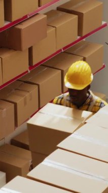 Dikey video: İstasyondaki sabit hatlı telefona cevap veren kadın yönetici, nakliye emrini hazırlamak için duvara monte edilmiş telefonla konuşuyor. Depoda telefon kullanan genç bir kadın, stok lojistiği..