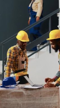 Vertical video: Group of young workers putting products in boxes, working on production and shipment in storage room. Colleagues checking orders before shipment, doing quality control in warehouse.