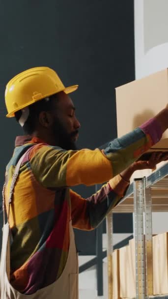 垂直ビデオ アフリカ系アメリカ人が商品の品質をチェックし ラックや棚から段ボール箱を使って商品を送る 在庫や小売店の注文 保管に従事する従業員 — ストック動画
