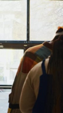 Dikey video: Depo çalışanları envanter üzerinde çalışıyorlar, barkodları tarayıcı ve tabletle tarıyorlar. Kadın ve erkek depoda ürünleri ve malzemeleri kontrol ediyor.