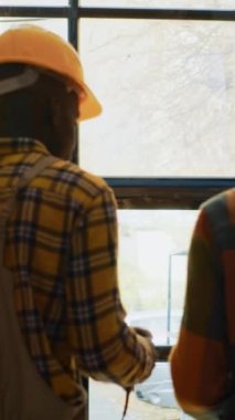 Vertical video: Two male employees working on logistics in depot with scanner and digital tablet, scanning shipment cargo with barcodes on shelves. People doing inventory with warehouse boxes. Tripod
