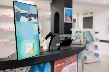 Depo vitriniyle donatılmış boş eczane masası ve müşterilerin gelip ilaç almaları için hazır bilgisayar. İlaç paketleri, takviyeler ve vitaminlerle dolu bir eczane.