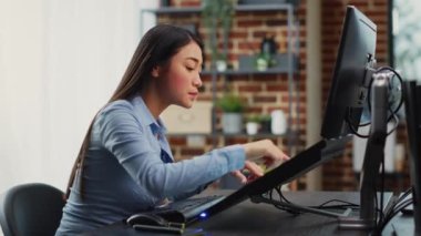 Profesyonel yazılımda oyun arayüzü oluşturmak için dokunmatik ekranı kullanan Asyalı kadın mühendis. Yapay zekayla çalışan yaratıcı geliştirici 3 boyutlu üretimi planlamak için.