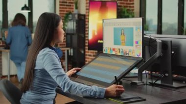 Kadın renkli editör tabletle rötuş yazılımı kullanıyor, ajans ofisinde multimedya üretimi üzerinde çalışıyor. Dokunmatik ekran ve stil ile fotoğraf ve resimleri düzenleyen Asyalı işçi.