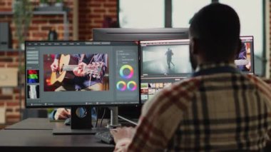 Profesyonel video editörleri renk derecelendirme ve ışıklandırmayı düzenlemeden önce film montajını analiz eder, yaratıcı ofiste takım çalışması yapar. Prodüksiyon çalışanları video görüntüleriyle çalışıyor..