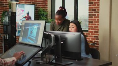 Çeşitli meslektaşlar, profesyonel bilgisayar yazılımı kullanarak yaratıcı ajans stüdyosunda 3 boyutlu içerik yaratmak için fikir üretmeye çalışıyorlar. Dijital proje geliştirme üzerinde çalışan genç bayan çalışanlar.