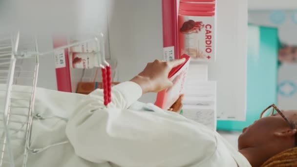 Вертикальне Відео Молода Жінка Перевіряє Коробку Таблеток Медичному Магазині Дивлячись — стокове відео