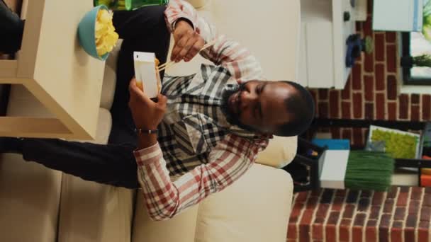 Vertical Video African American Man Enjoying Asian Food Delivery Box — Stockvideo