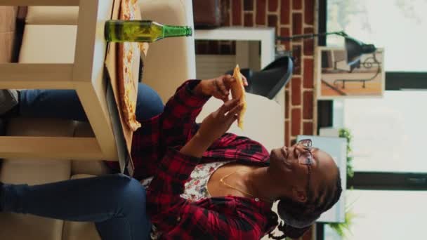 Вертикальне Відео Африканська Американка Дивиться Телевізор Їсть Піцу Сміється Над — стокове відео