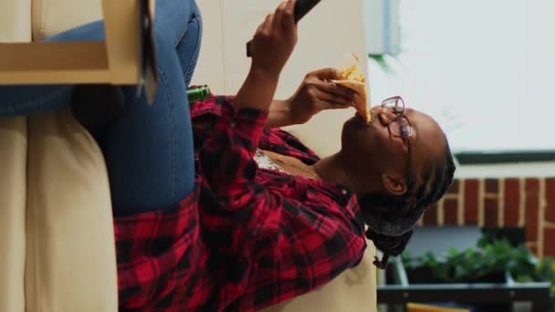 Vertical Video Female Adult Eating Pizza Slices Takeaway Sofa Enjoying — Stockvideo