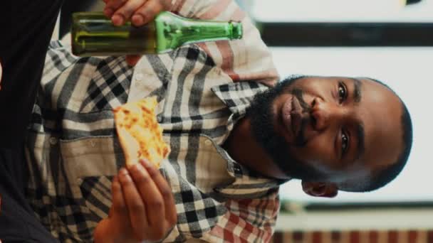 Pionowe Wideo Wesoły Młody Facet Pijący Piwo Jedzący Pizzę Oglądający — Wideo stockowe
