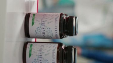 Vertical video: African american woman taking vitamins from shelves, looking to buy prescription treatment and pharmaceutics. Young adult checking medicaments and heealhcare products. Close up.