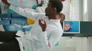 Vertical video: Drugstore customer reading leaflet on packs of pills, checking medical products from drugstore. Young adult looking at medicaments and supplements, buying prescription medicine.
