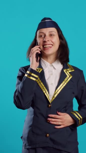 垂直ビデオ 若い航空会社は 携帯電話の通話でチャットし 楽しく 幸せな気分で リモートディスカッションをしています 航空業界のための航空制服を着て陽気な空気のホステス 電話回線 — ストック動画